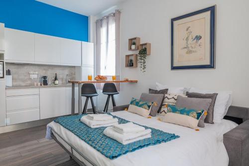 Un dormitorio con una cama grande con toallas. en Le Coq Albert II - Monaco border - WiFi, en Beausoleil