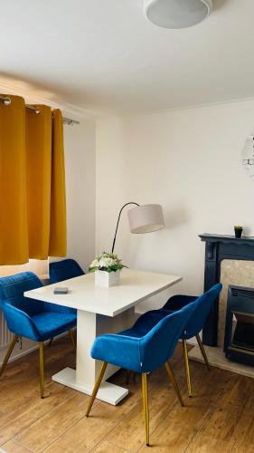 a white table with blue chairs and a fireplace at Cozy plaza lodge in Rochester