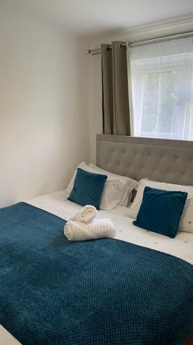 a bed with two blue pillows and a towel on it at Cozy plaza lodge in Rochester