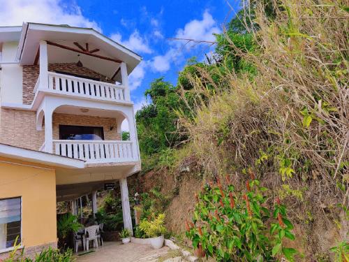 uma casa com uma varanda no lado de uma colina em Anne Hillside Apartment em Victoria