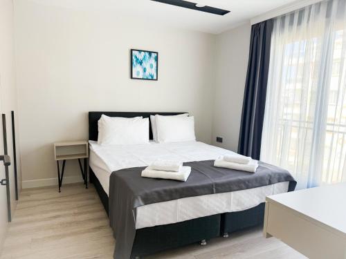 a bedroom with a bed with two towels on it at Moon City in Antalya