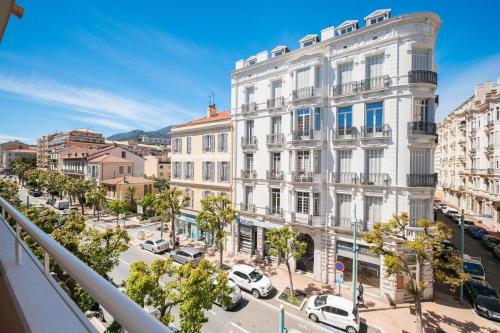 a city street with cars parked in front of a building at Le COQ Symphonie- Parking - Bord de mer in Menton