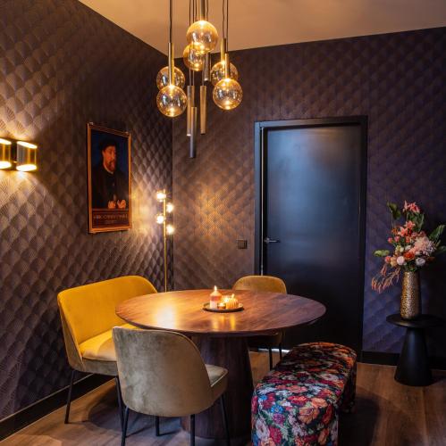 a dining room with a table and chairs at De Nassau - In de winkelstraat in Breda
