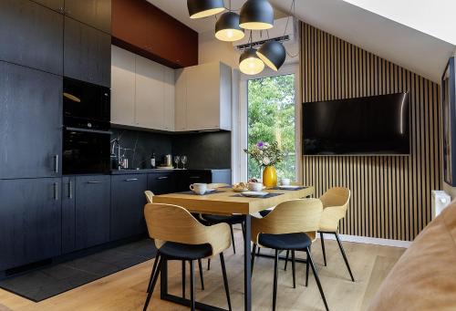 une cuisine avec une table et des chaises dans une cuisine dans l'établissement Apartament Na Urlop - Wisła - Magiczny Horyzont, à Wisła
