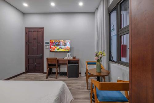 a bedroom with a bed and a desk and a table at Silana River Light Hotel in Da Nang