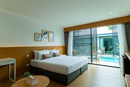 a hotel room with a bed and a large window at Xen Pool Access in Chalong 