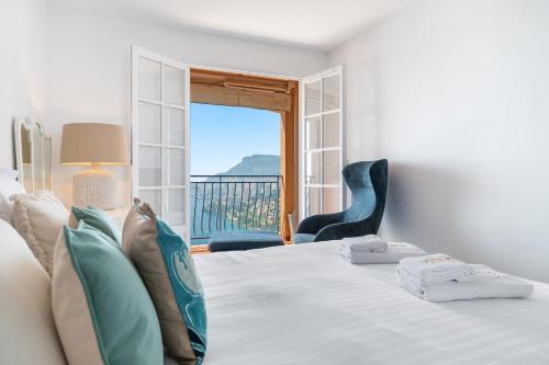 ein Schlafzimmer mit einem Bett und einem Fenster mit Aussicht in der Unterkunft Le COQ Grace Kelly - Parking - AC - Amazing view in Roquebrune-Cap-Martin