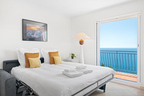 a bedroom with a bed with a view of the ocean at Le COQ Gabriel - Parking - Amazing view in Roquebrune-Cap-Martin