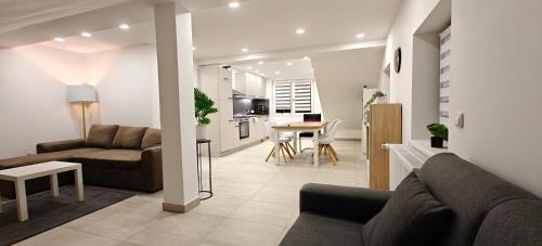 a living room with two couches and a table at Seenland Getaway - Haus am Berg in Pleinfeld