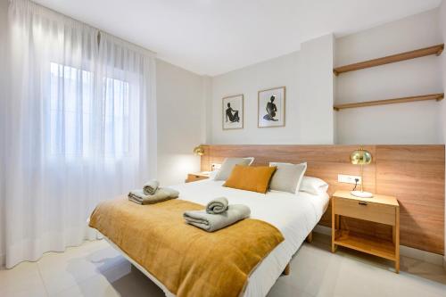 a bedroom with a large bed with towels on it at Picasso 2 Royal in Marbella