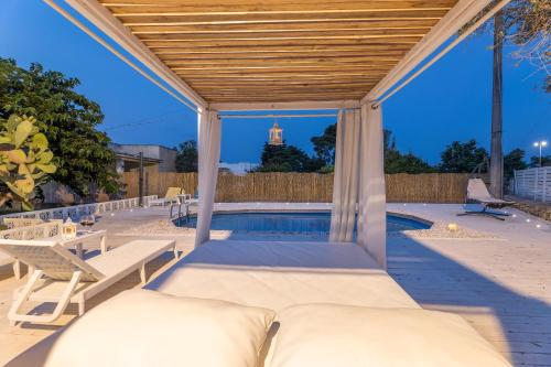 a patio with a bed and a swimming pool at Villa Desideria in Matino