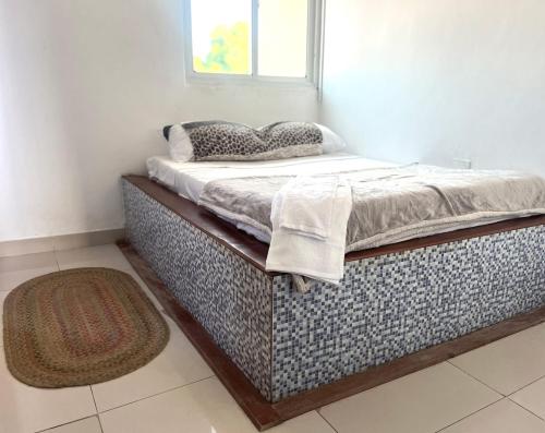 a bed in a room with a pillow on it at O Retorno do Prazer 