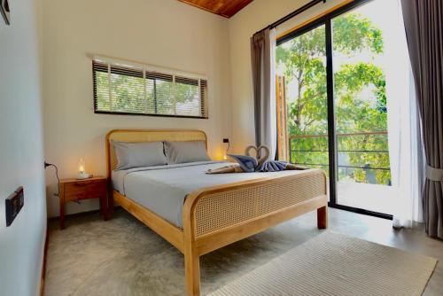 a bedroom with a bed and a large window at Yume17 in Chaloklum