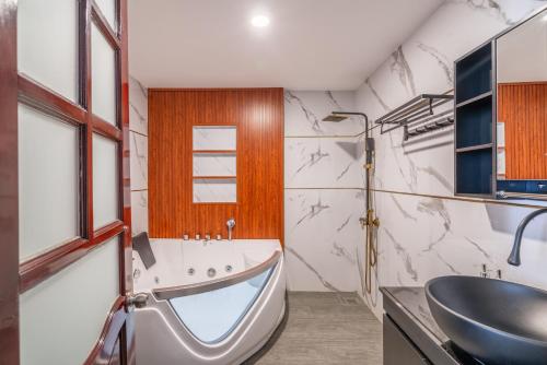 un baño con lavabo y bañera en The Palms Hotel Phan Thiết, en Phan Thiet