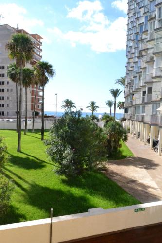 a view of a park with palm trees and buildings at Safestay Calpe Seafront - Apartment Atlantico in Calpe