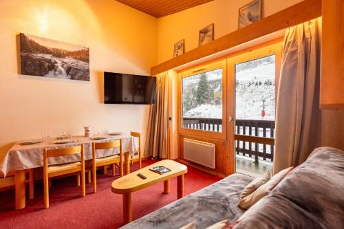 Una sala de estar con una mesa y un comedor. en Cembros #20 - 4 guests - Ski in - Ski out, en Méribel
