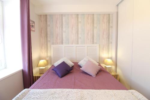 a bedroom with a large bed with two pillows on it at Le Rivage in Sainte-Marie-de-Ré