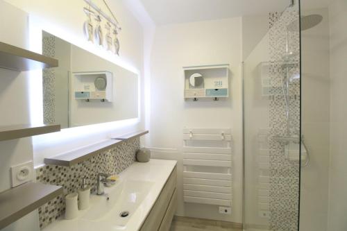 a white bathroom with a sink and a shower at Gite La Paillotte, Ile De Ré in Sainte-Marie-de-Ré