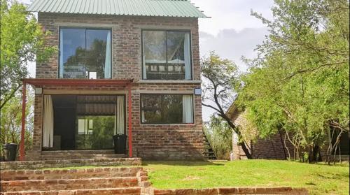 a brick house with a green roof at Bloemhof Riverside Chalets 