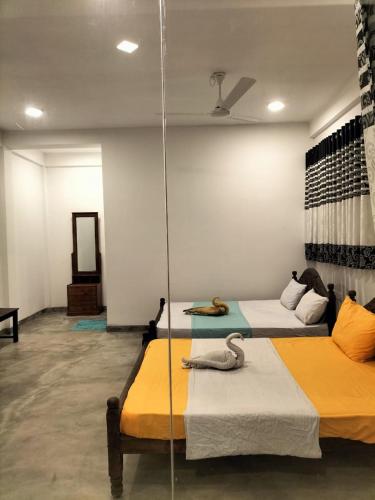 a room with two beds and a mirror at Ocean Hill in Arugam Bay