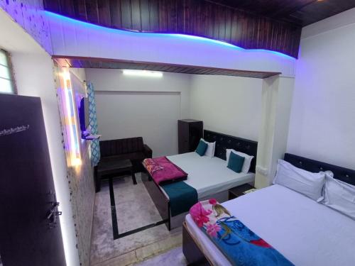 a small room with two beds and a table at Hotel Veeras in Palāi