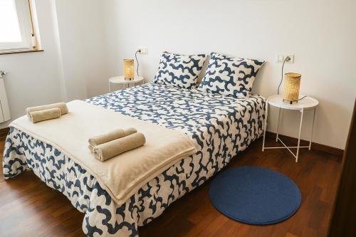 a bedroom with a bed with a blue and white blanket at Casa Vixoi, a 5Km Catedral in Santiago de Compostela