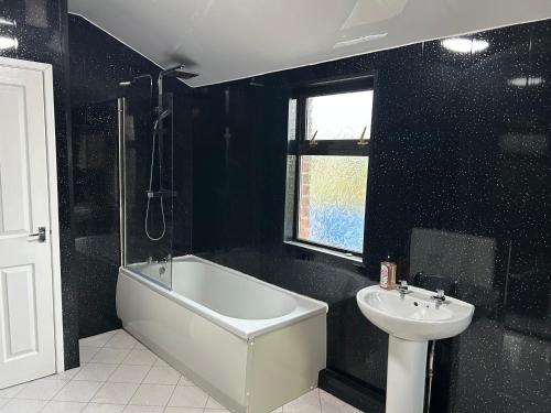 a bathroom with a bath tub and a sink at 4 bedroom house in Shotton Colliery in Durham