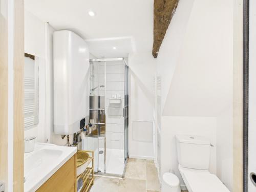 a white bathroom with a sink and a toilet at Superbe chaumière pour 6 personnes avec jardin in Ploeren