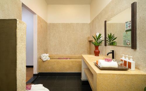 a bathroom with a sink and a bath tub at Residence Indochine D'angkor in Siem Reap