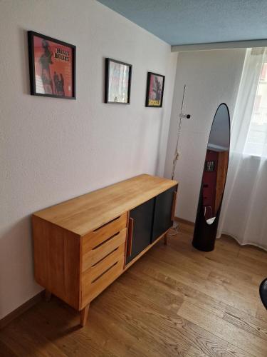 a living room with a wooden dresser and a mirror at Kugelgasse Apartments - Smart Living by Klang und Kleid in St. Gallen