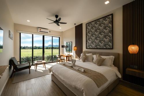 Un dormitorio con una cama grande con ventilador de techo. en Villa Moo Moo, Pool Villa with Sunset & Paddy Field Views, en Langkawi Intl
