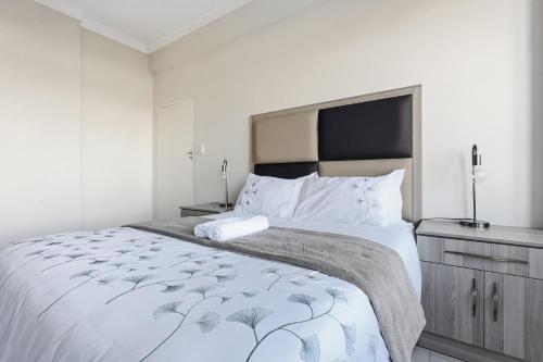 ein Schlafzimmer mit einem großen Bett und einer Kommode in der Unterkunft Beach Hurst 303 in Durban