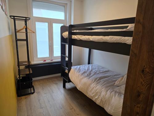ein Schlafzimmer mit Etagenbett und Fenster in der Unterkunft Huisje Well Tevree in Roesbrugge-Haringe