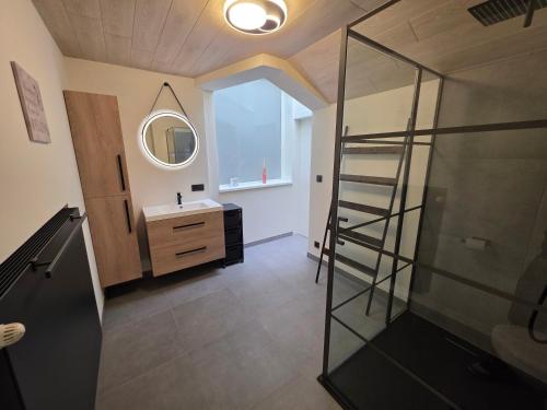 ein Badezimmer mit Glasdusche und Waschbecken in der Unterkunft Huisje Well Tevree in Roesbrugge-Haringe