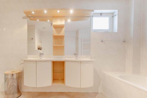 a bathroom with a sink and a tub and a mirror at Dijkvilla - 5 personen in Holle Poarte