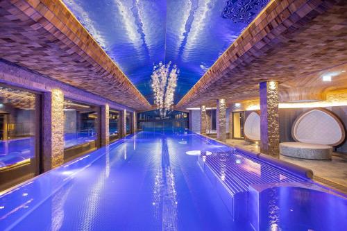 a swimming pool in a building with a blue ceiling at Großmitt in Pertisau