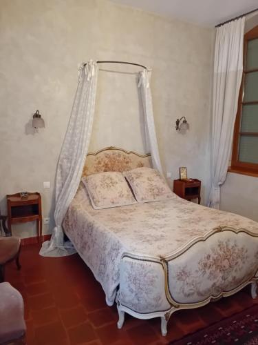 une chambre avec un lit à baldaquin dans l'établissement L'Albarande, à Saint-Rambert-en-Bugey