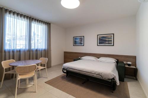 Capiago IntimianoにあるBilocale Viola - Cascina Da Rosaのベッドとテーブルと椅子のある寝室