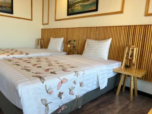 um quarto de hotel com duas camas com lençóis brancos em Bien Ngot Resort Phu Quoc em Duong Dong