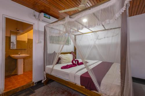 a bedroom with a bed with a canopy at Serendipity Beach Hotel in Unawatuna