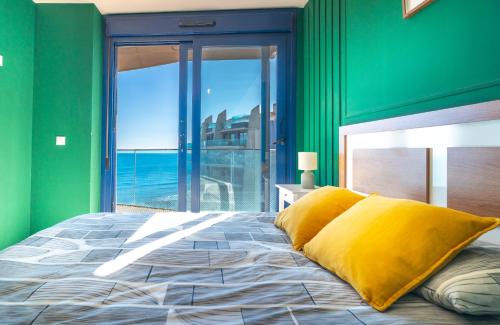 une chambre avec des murs verts et un lit avec des oreillers jaunes dans l'établissement Seaview Horizon, à Punta Prima