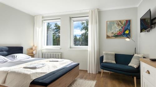 a bedroom with a bed and two blue chairs at Krechowiak in Augustów