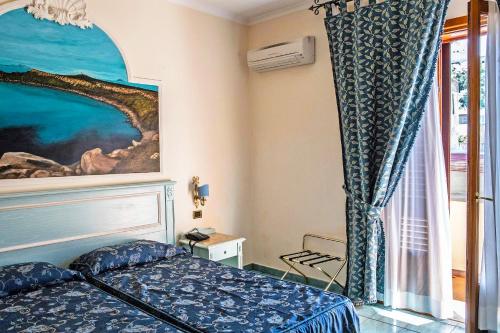 een slaapkamer met een bed en een schilderij aan de muur bij Garibaldi Houses in Milazzo