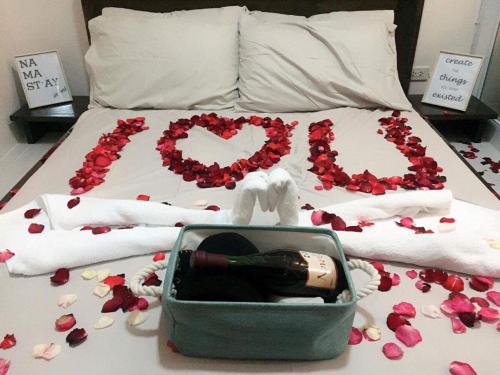 a bed with a bottle of wine and flowers on it at Chloe's Place Tagaytay Taal View Staycation Condo in Tagaytay