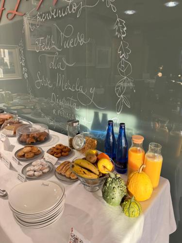 a table topped with plates and bowls of fruits and vegetables at Hotel Rural Peñalabra in Cervera de Pisuerga