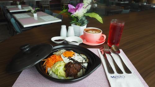 uma mesa com um prato de comida e uma xícara de café em Novel Hotel Manila em Manilla