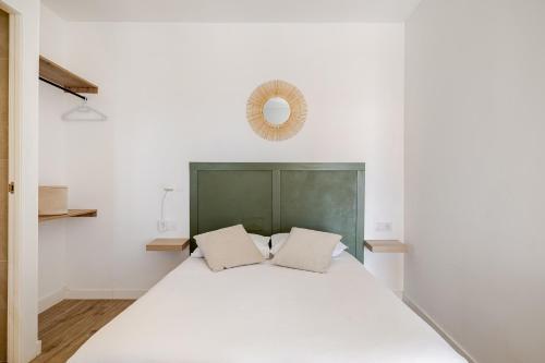 a bedroom with a large white bed with two pillows at Tiny house with sunset over the ocean in Oia