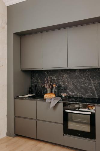 a kitchen with white cabinets and a stove at Le Nid du Château - Cocon avec Bagagerie in Angers