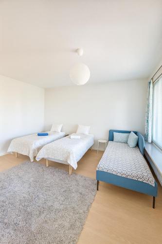 a room with two beds and a couch in it at Bright Cozy Private Rooms 3min to Metro in Helsinki