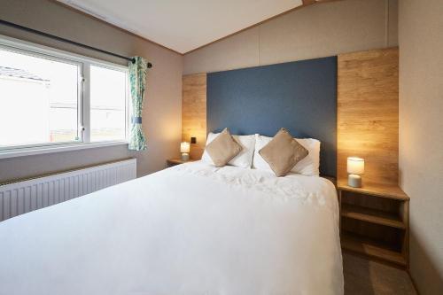 een slaapkamer met een groot wit bed en een raam bij Host & Stay - Grange in Morecambe